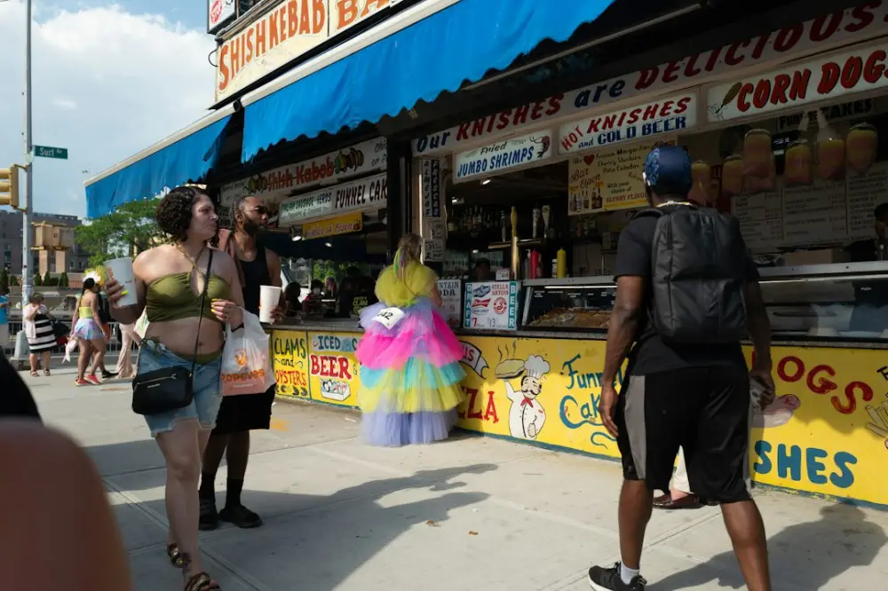 People gather outside a food stand on a sunny day